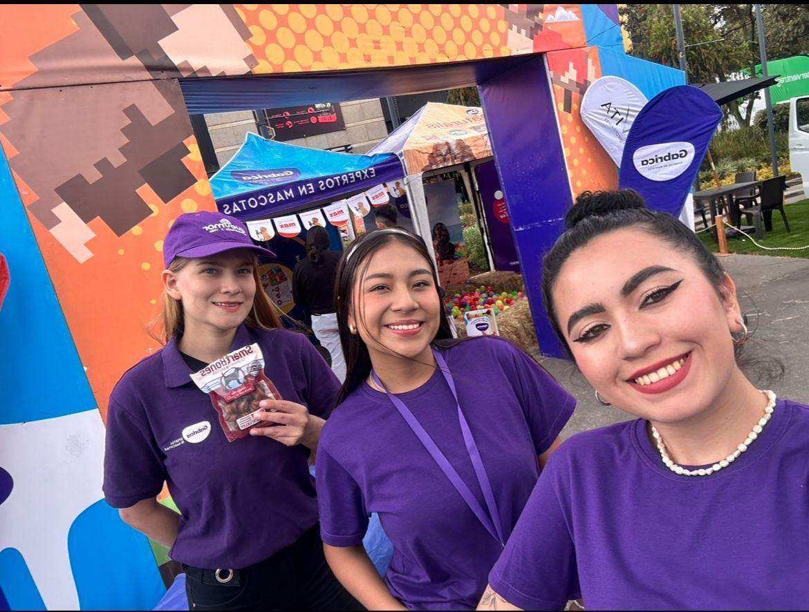 Promotoras de AgenciaBTL con uniforme morado en un evento de marcas para mascotas