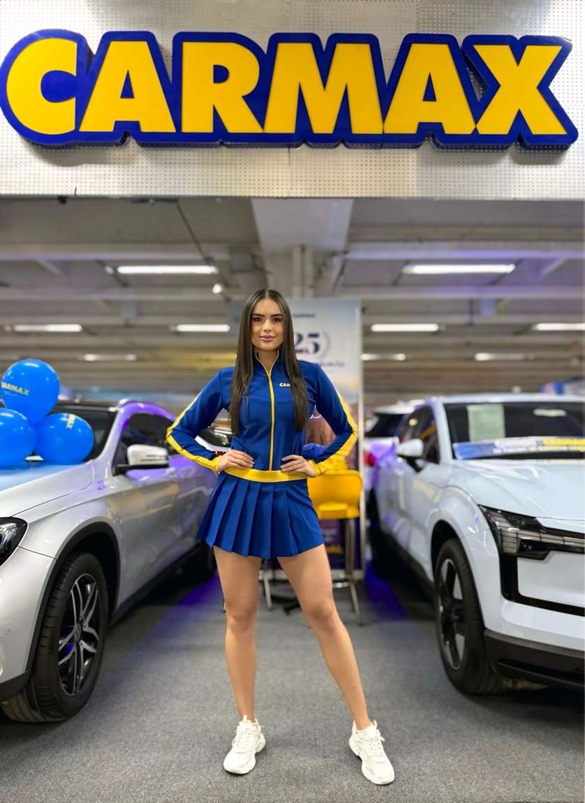 Modelo de AgenciaBTL con uniforme de marca en una vitrina de vehículos