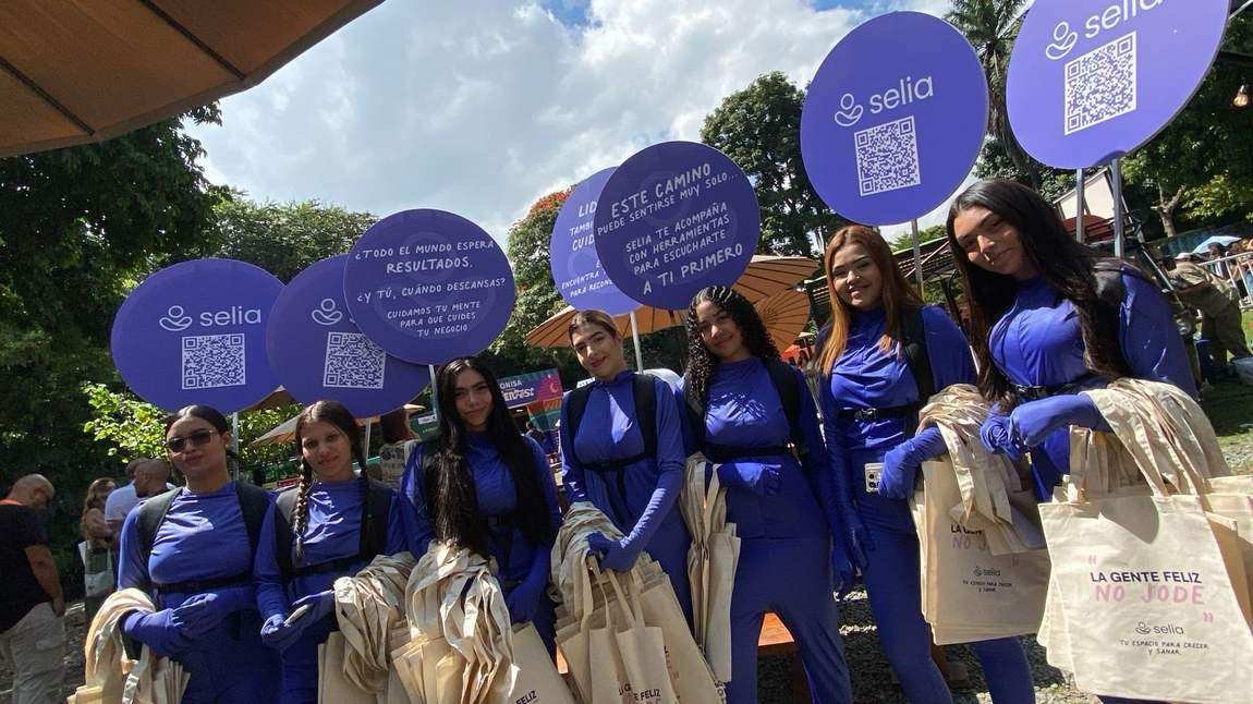 Equipo de AgenciaBTL con enterizos de marca entregando bolsas en un evento